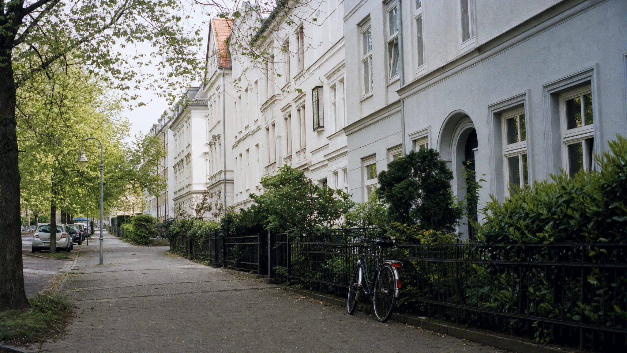 Ruhige Wohnstraße mit sanierten Altbauten am hellen Vormittag
